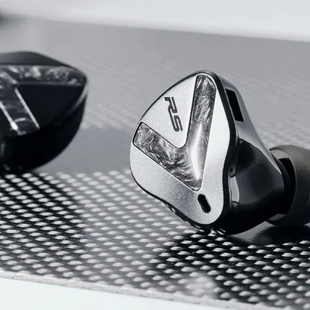 Softears RSV MK2 earphones close-up on carbon-fibre textured surface showing RS logo faceplate